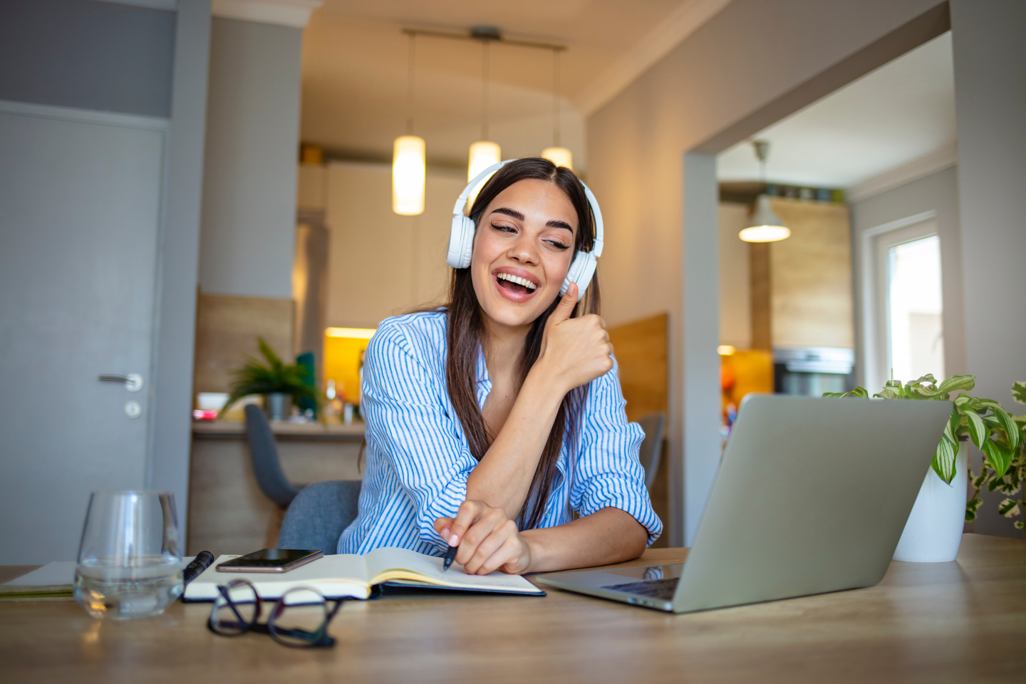Person taking a work call on a headset while working from home