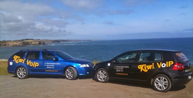 Two branded Kiwi VoIP cars parked on the coast at Opunake, Taranaki, in the early days of the company